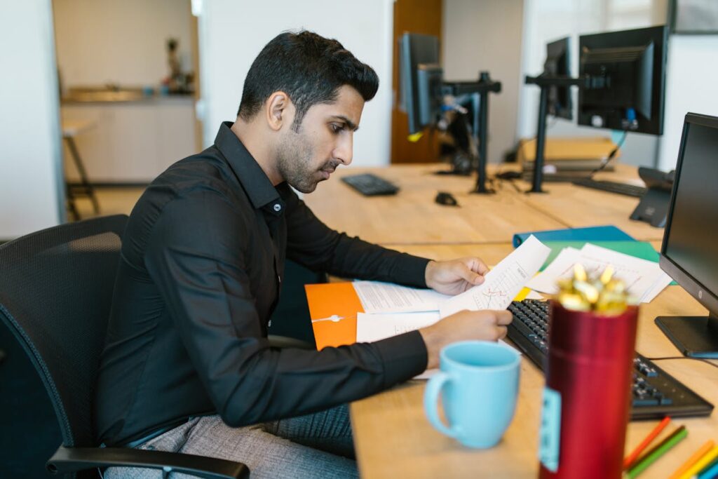Professional reviewing documents at his desk in an office setting