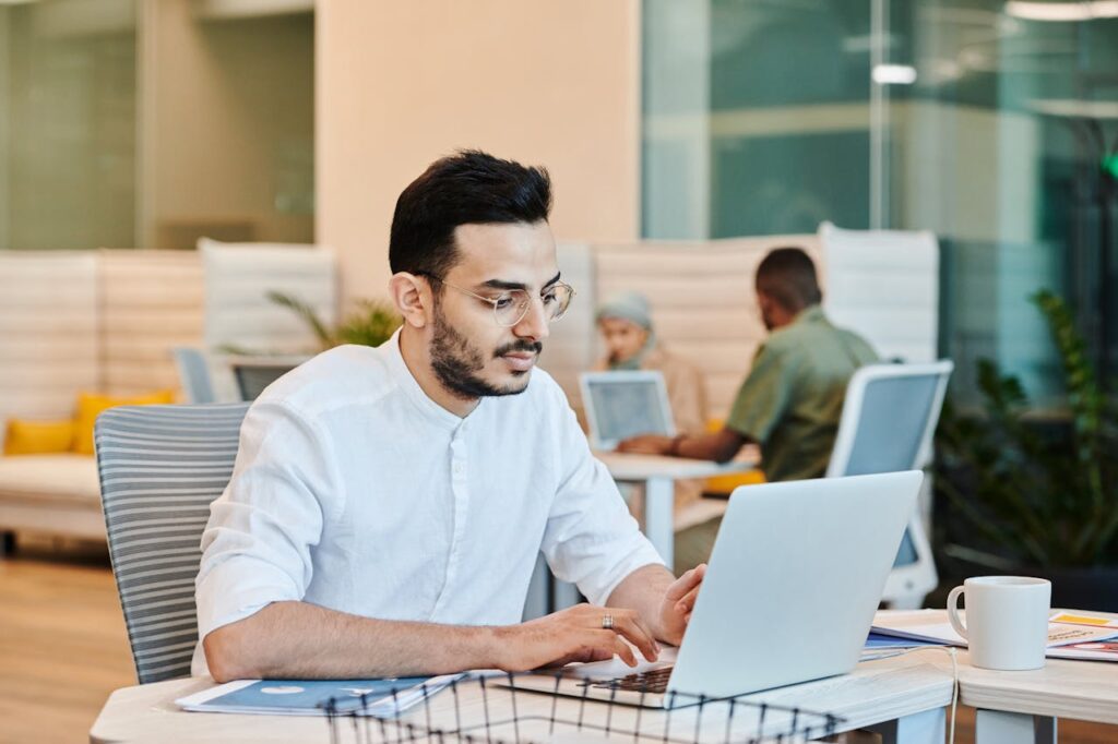 Professional working on a laptop in a modern office environment