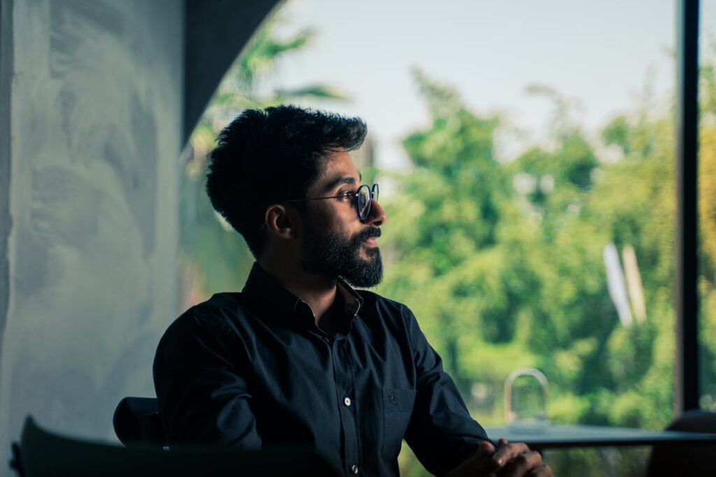 Professional sitting calmly looking away with no active work or device use