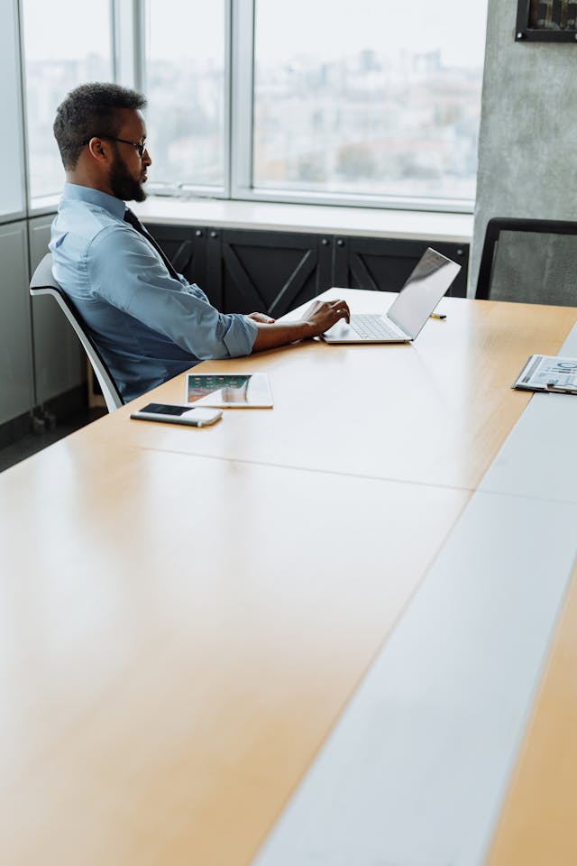 Professional working on laptop in office unaware of passive online presence