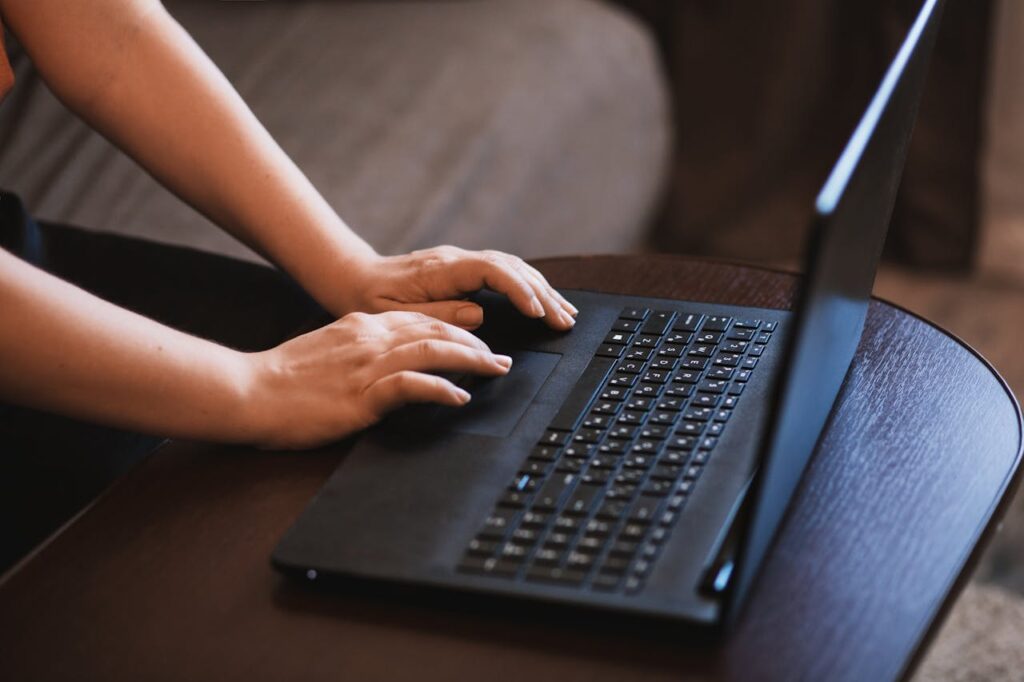 Close-up of hands typing on a laptop with no distinct or identifying context