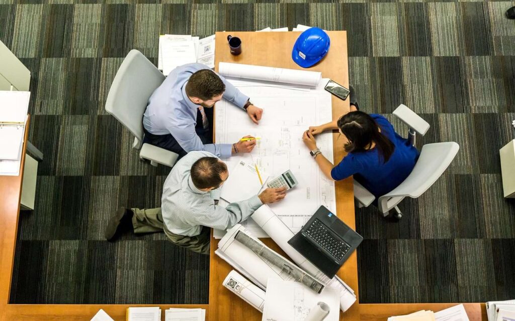 Top-down view of professionals working together, representing peer-level comparison and how others’ work influences LinkedIn perception