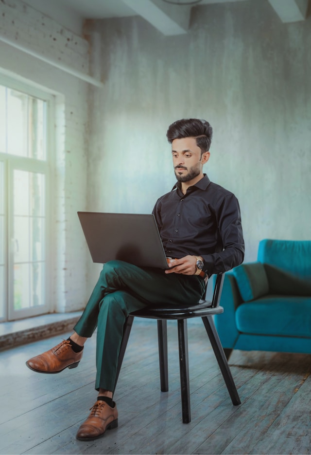 Professional working on a laptop with a composed but undefined presence, reflecting LinkedIn summary mistakes that reduce perceived seniority