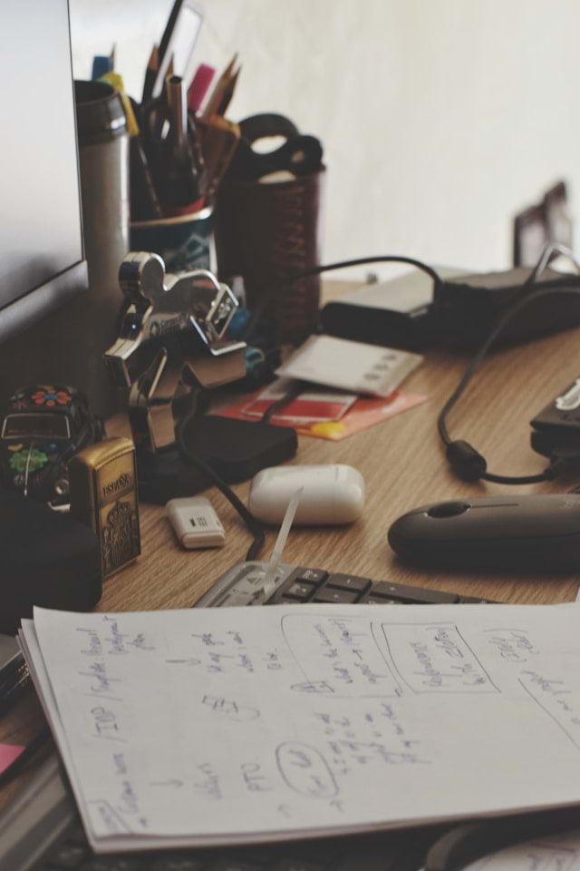 Slightly cluttered workspace with notes and everyday objects creating subtle inconsistency