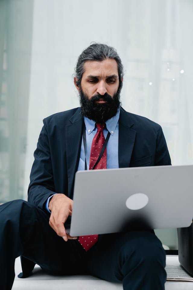 Experienced corporate professional reviewing information on a laptop in a business setting