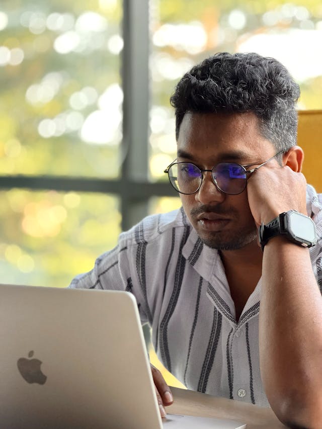 Professional thoughtfully reviewing information on a laptop in a quiet workspace