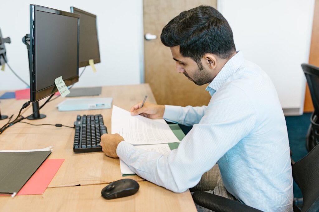Professional reviewing information on a laptop at an office desk