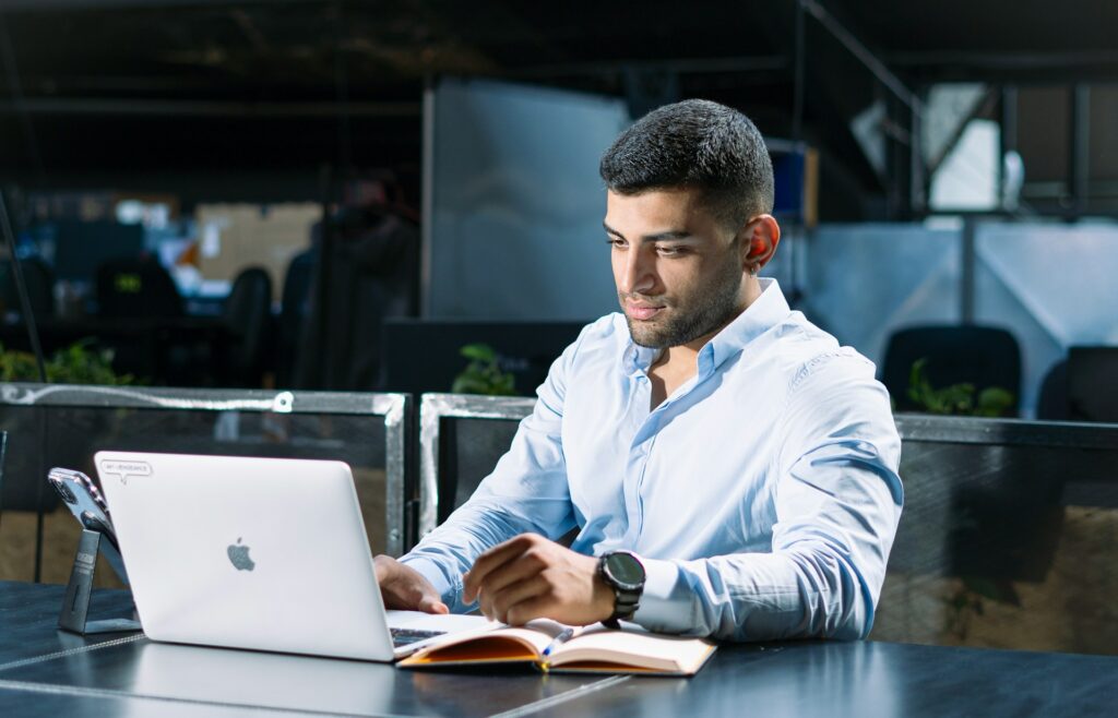 Professional working thoughtfully on a laptop in a modern corporate office