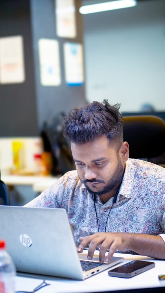 Focused professional working on a laptop in a modern office workspace