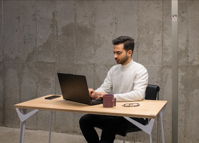 Professional working quietly on a laptop at a clean minimalist workspace